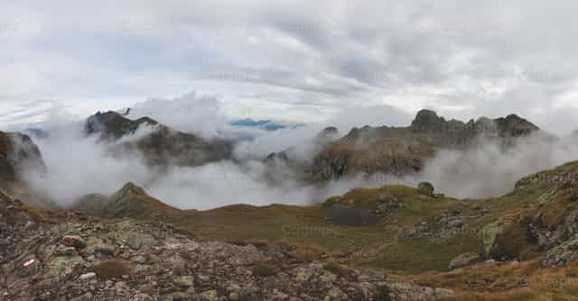 Panorama alpino con nubes en los valles - Banco de imágenes católicas - Fotografía por Michelangelo Oprandi