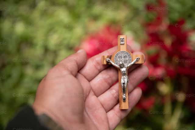 Crucifijo sostenido en oración - Banco de imágenes católicas - Fotografía por Carolina BR