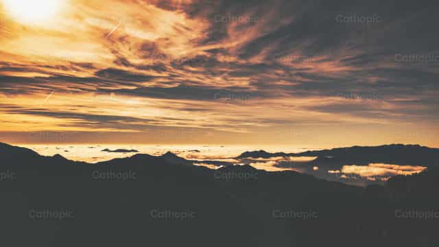 Panorama alpino con nubes bajas entre las montañas - Banco de imágenes católicas - Fotografía por Michelangelo Oprandi