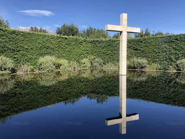 Spiegelbild des Kreuzes im See - Katholische Stockfotos