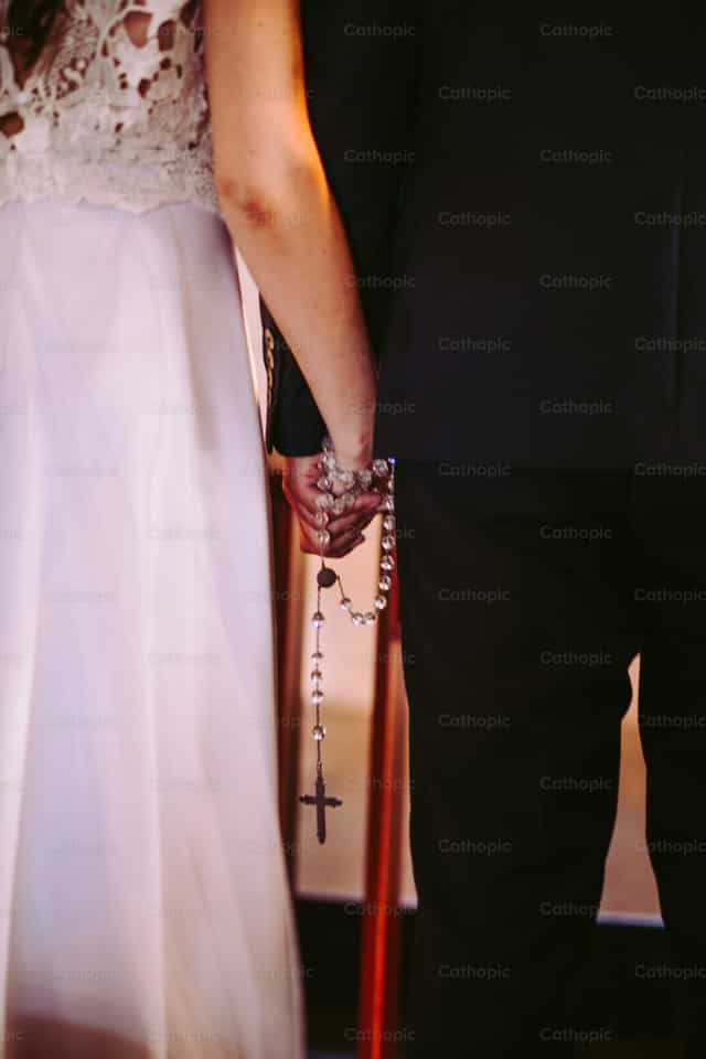 Couple holding hands with the rosary - Catholic stock images
