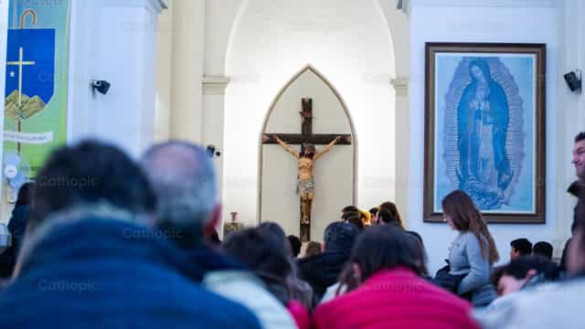 Crucifijo frente a una comunidad - Banco de imágenes católicas - Fotografía por Lucia Ceballos y Spina