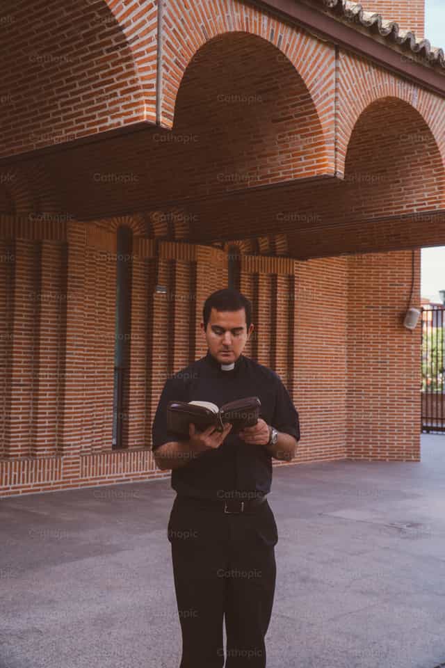 O sacerdote caminha e reza com a Palavra de Deus - Imagens católicas de stock - Foto de Almures Studio