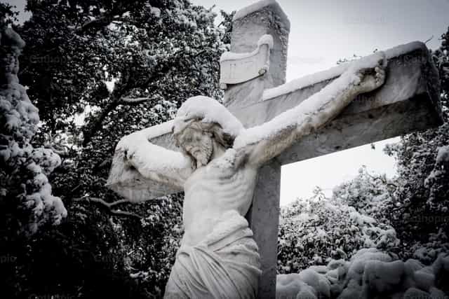 Jesucristo en la cruz en medio de la nieve - Banco de imágenes católicas