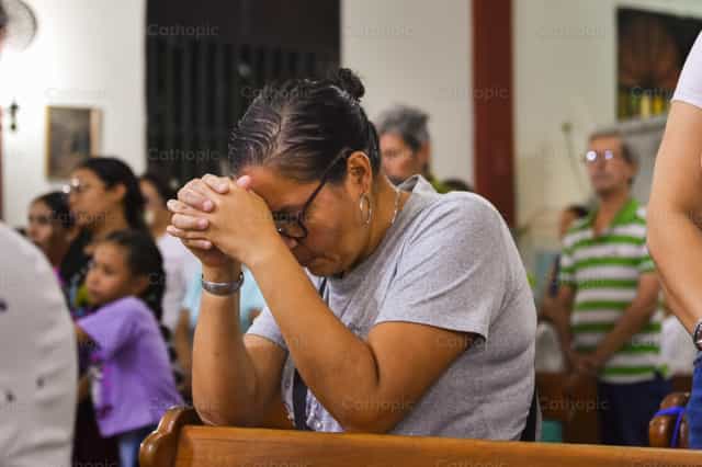 Oración profunda después de comulgar - Banco de imágenes católicas - Fotografía por Miguel White
