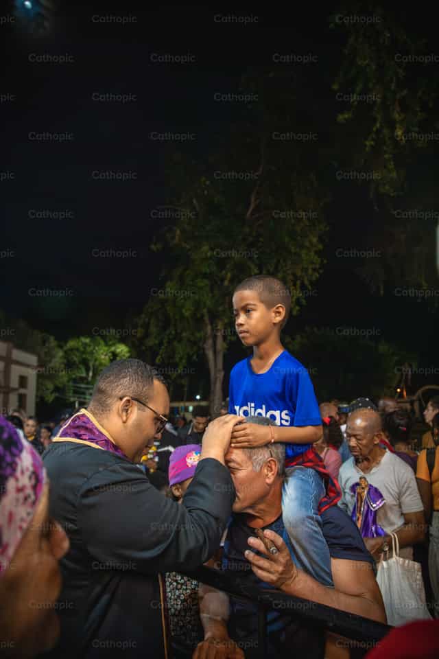 Sacerdote alegre bendice a familia - Banco de imágenes católicas - Fotografía por Yandry Fernández Perdomo