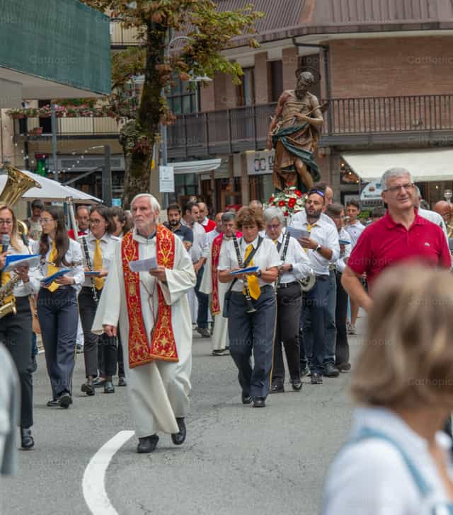 Procesión religiosa encabezada por el portacruz por las calles - Banco de imágenes católicas - Fotografía por Pierluigi Palazzi