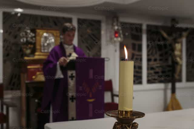 Bougie allumée sur l’autel pendant la Messe - Images catholiques de stock