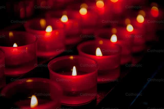 Votive candles lit in church - Catholic stock images - Photo by Pierluigi Palazzi