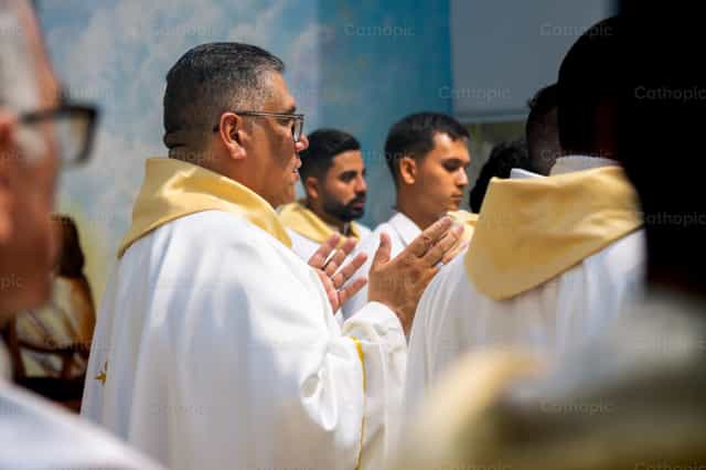 Sacerdote com as mãos abertas em oração - Imagens católicas de stock