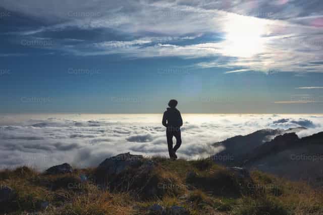 Einsamkeit in den Bergen über einer Wolkenmeer - Katholische Stockfotos