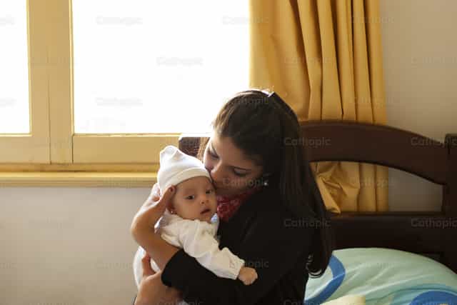 Joven con bebé en brazos - Banco de imágenes católicas - Fotografía por Pitangus Alfonso Asensio