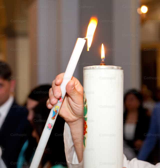 Hand hält eine brennende Kerze in einer Kirche - Katholische Stockfotos
