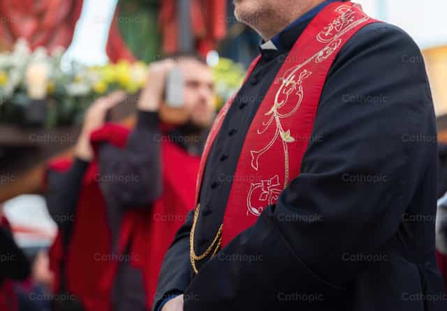 Sacerdote católico con estola roja en Semana Santa - Banco de imágenes católicas