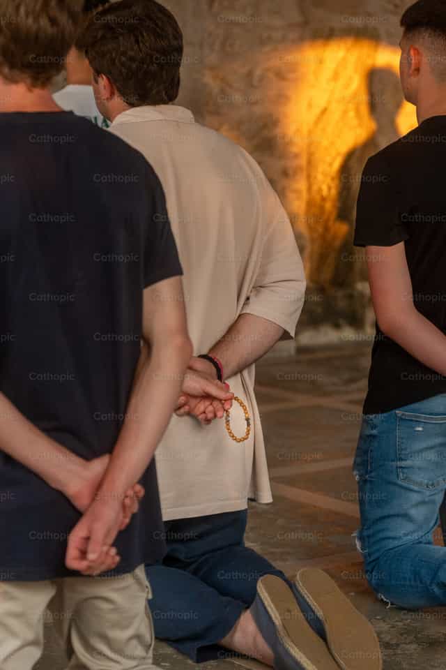 Jóvenes arrodillados rezando el Rosario - Banco de imágenes católicas - Fotografía por Rodrigo De Miguel