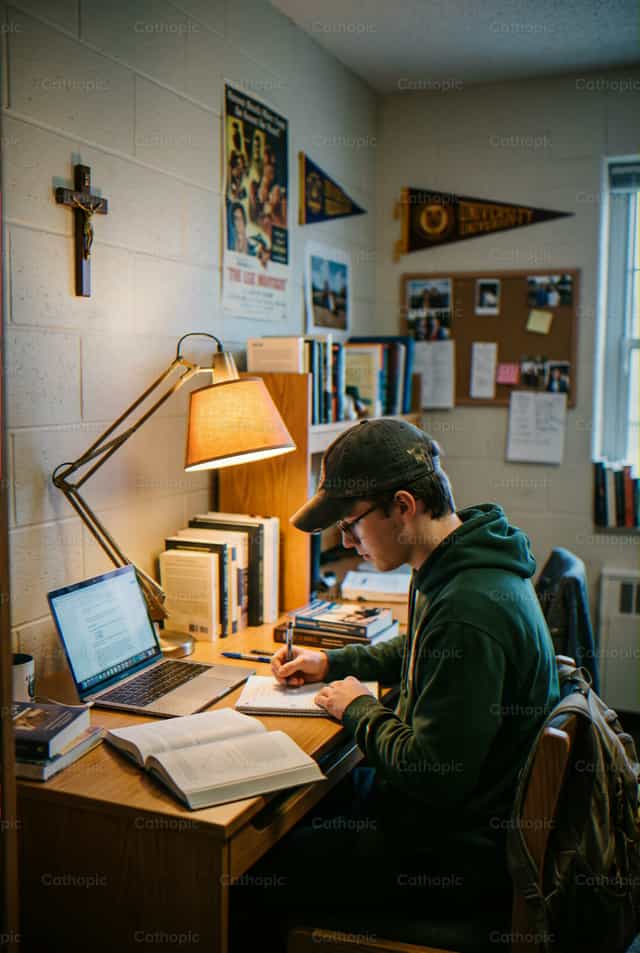Étudiant catholique étudiant les Écritures dans sa chambre de dortoir - Images catholiques de stock - Photo de Enma Bastidas