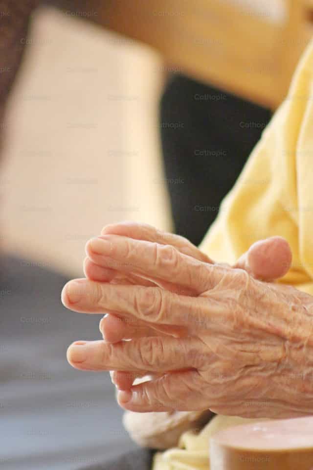 Manos ancianas unidas en oración - Banco de imágenes católicas - Fotografía por Cristina Grigore