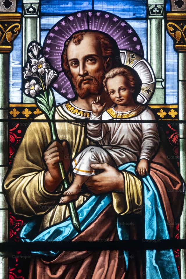 José sosteniendo al niño Jesús Cristo en sus brazos - Banco de imágenes católicas - Fotografía por Joan Sutter