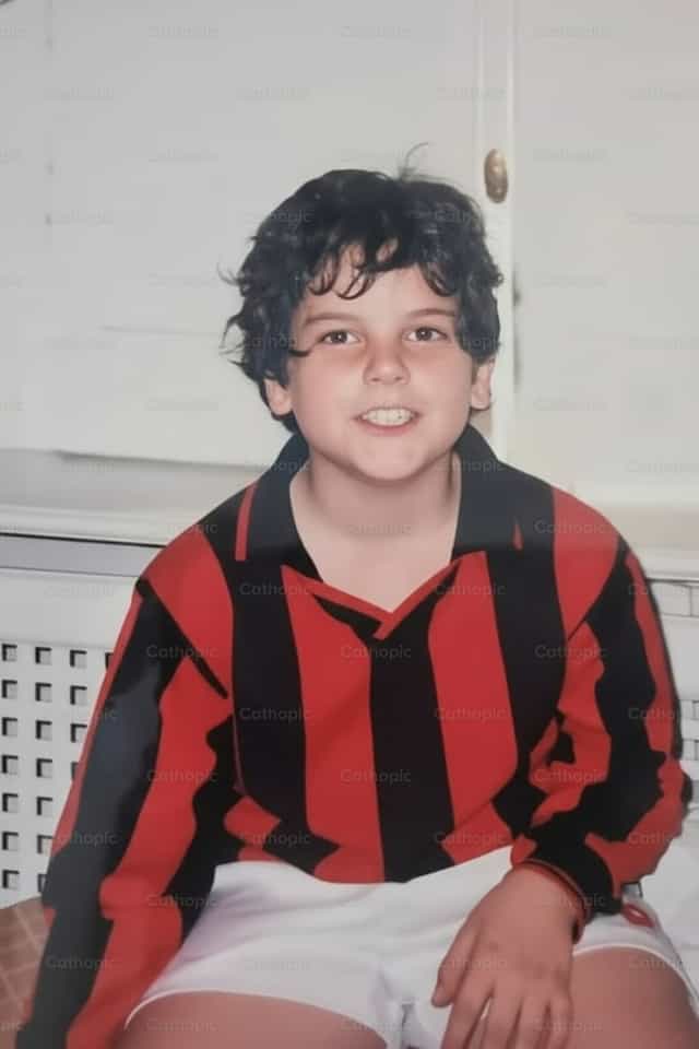 San Carlo Acutis che gioca a calcio - Immagini stock cattoliche