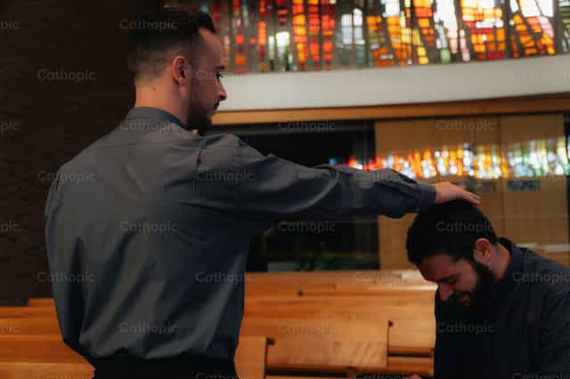 Sacerdote imponiendo su mano a los jóvenes - Banco de imágenes católicas