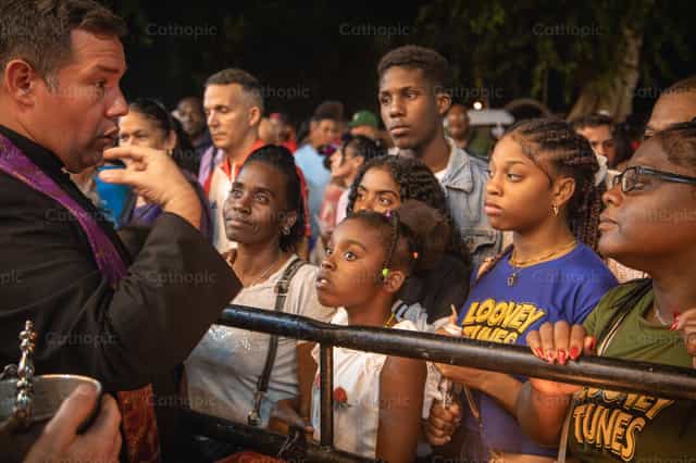 Sacerdote conversa con una persona en un santuario - Banco de imágenes católicas - Fotografía por Yandry Fernández Perdomo