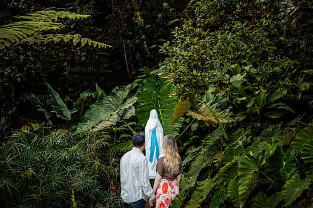 Pareja frente a Nuestra Señora de Lourdes - Banco de imágenes católicas