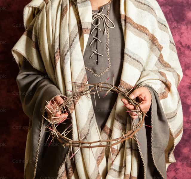 Actor in biblical clothing holds a crown of thorns - Catholic stock images - Photo by Antonio Gravante