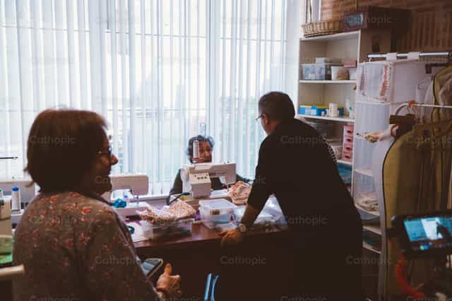 Priest in conversation with parish employees - Catholic stock images - Photo by Almures Studio