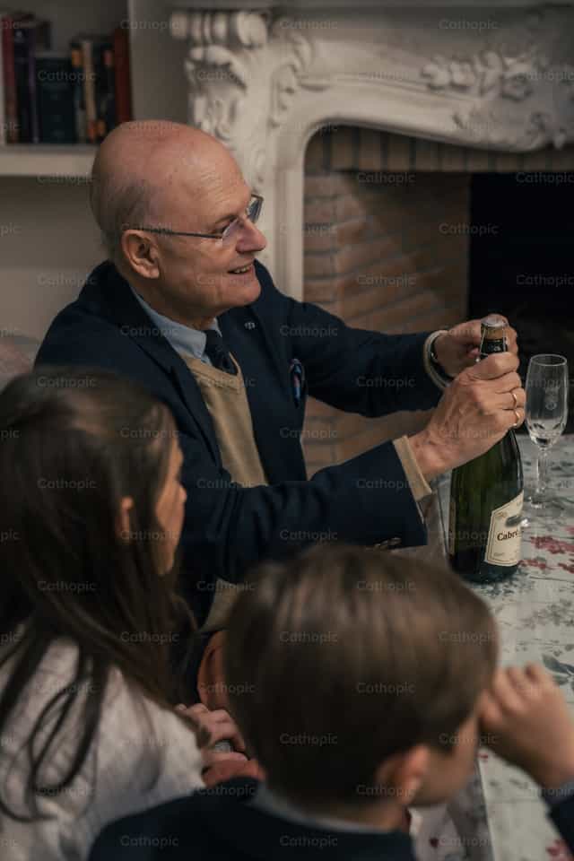 Binubuksan ng Lolo ang Bote ng Alak - Mga Catholic stock image