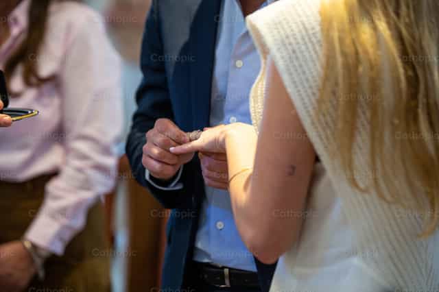 Esposa recibiendo alianza matrimonial - Banco de imágenes católicas - Fotografía por Lucia Ceballos y Spina
