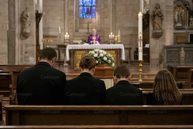 Familia en una misa fúnebre católica - Banco de imágenes católicas - Fotografía por Filip Pleše