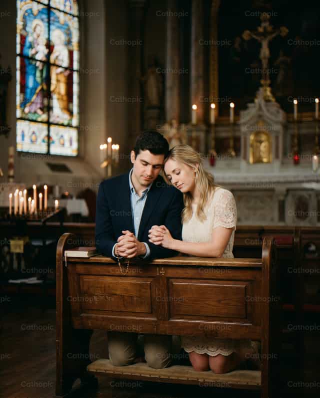 Pareja joven rezando en una iglesia - Banco de imágenes católicas - Fotografía por Noemí Márquez