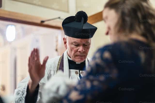 Sacerdote faz o sinal da cruz sobre o bebê - Imagens católicas de stock - Foto de Carlos Sierra