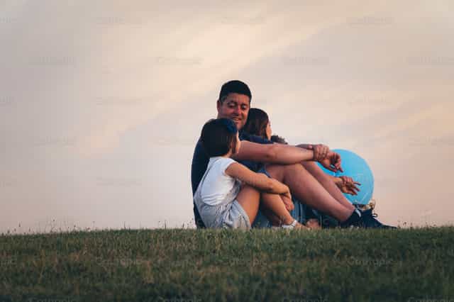 Familia unida viendo la puesta de sol - Banco de imágenes católicas - Fotografía por Almures Studio