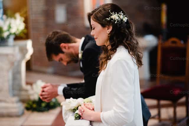 Matrimonio orando en celebración Eucaristica - Banco de imágenes católicas