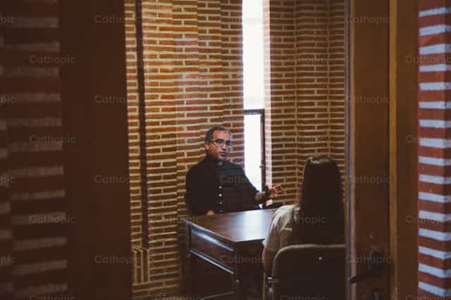 Sacerdote dando direccion espiritual - Banco de imágenes católicas - Fotografía por Almures Studio