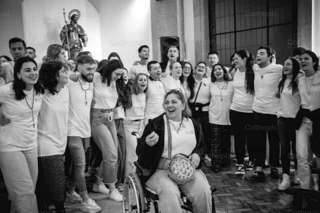Young people praying with a woman in a wheelchair - Catholic stock images - Photo by Yandry Fernández Perdomo