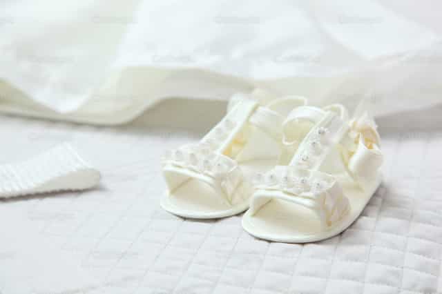 Scarpine bianche per il santo battesimo - Immagini stock cattoliche