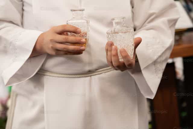 Sacerdote com as galhetas - Imagens católicas de stock