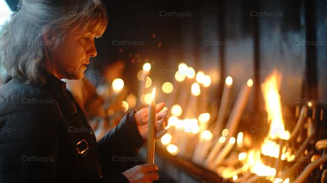 Mujer con vela encendida - Banco de imágenes católicas - Fotografía por Lupe Belmonte
