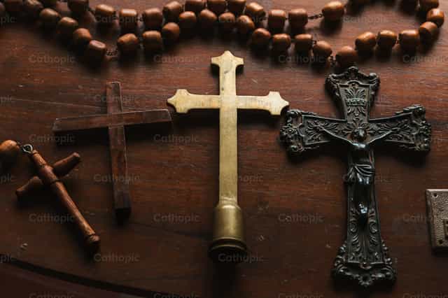 Colección de cruces de madera y metal sobre una mesaw - Banco de imágenes católicas - Fotografía por Piero Insfran