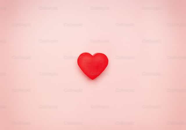 Corazón rojo en el centro de un fondo rosa - Banco de imágenes católicas - Fotografía por Antonio Gravante