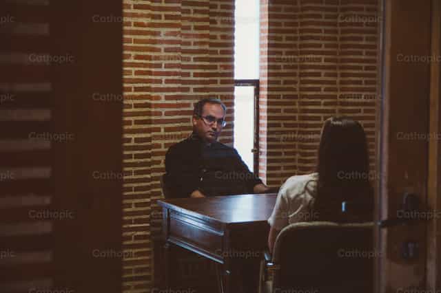 Sacerdote dando direccion espiritual - Banco de imágenes católicas - Fotografía por Almures Studio