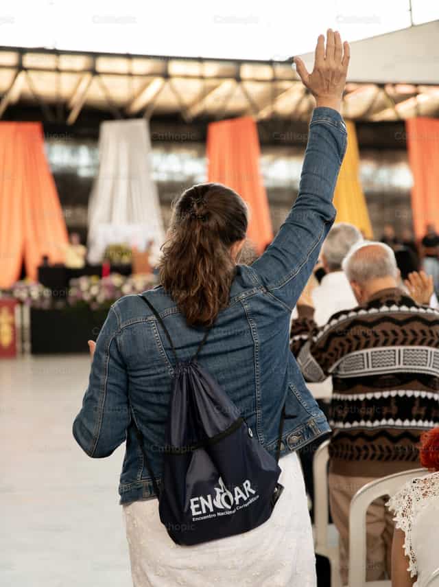 Mano levantada hacia el altar - Banco de imágenes católicas - Fotografía por Carolina BR