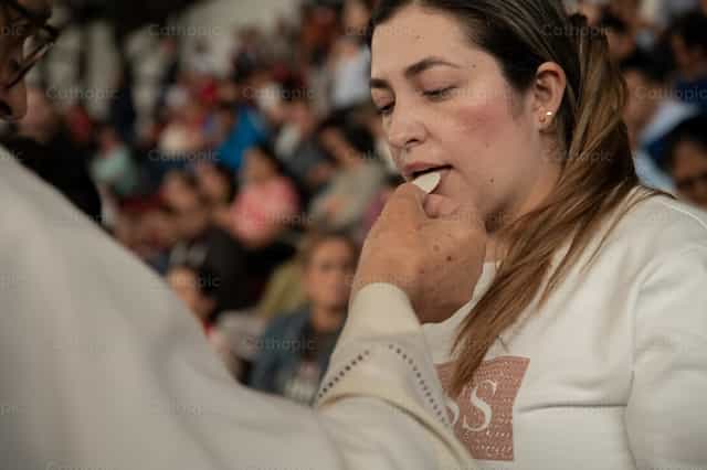 Mulher recebendo a Sagrada Comunhão - Imagens católicas de stock