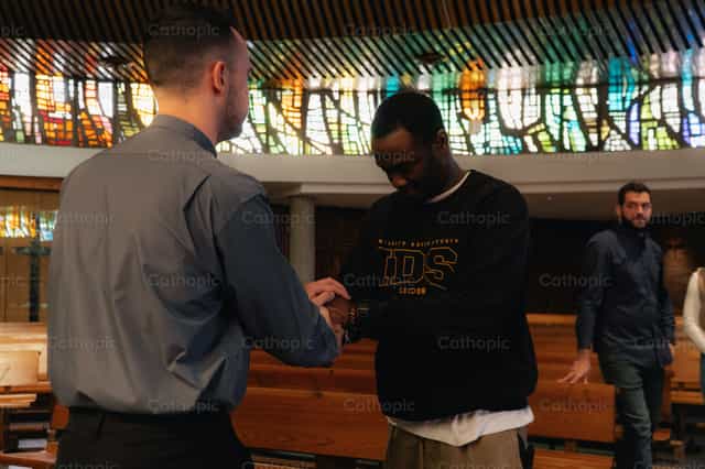 Young man and Priest saying goodbye - Catholic stock images