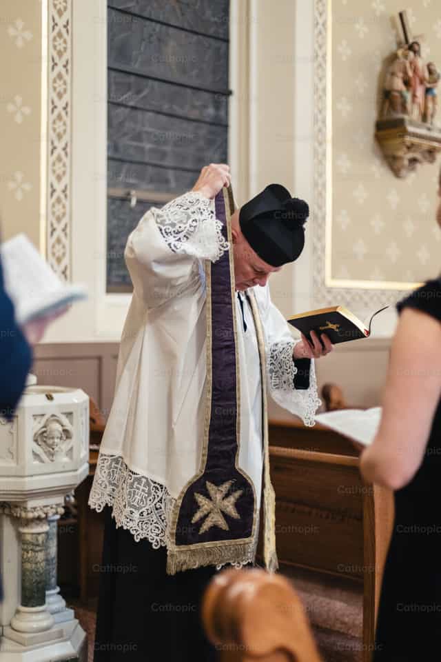 Sacerdote se quita la estola - Banco de imágenes católicas
