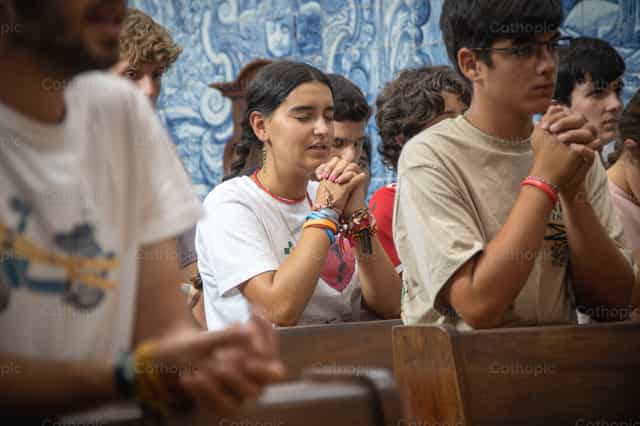 Una joven reza en la iglesia durante la JMJ 2023 - Banco de imágenes católicas - Fotografía por Yandry Fernández Perdomo