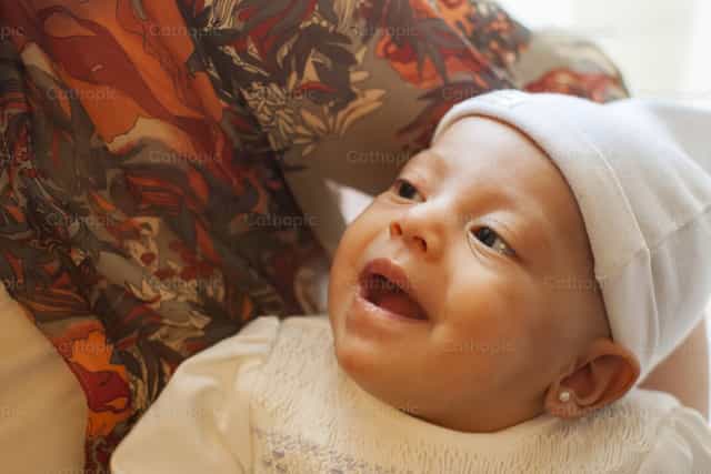 Nina recien nacida sonriendo - Banco de imágenes católicas - Fotografía por Pitangus Alfonso Asensio