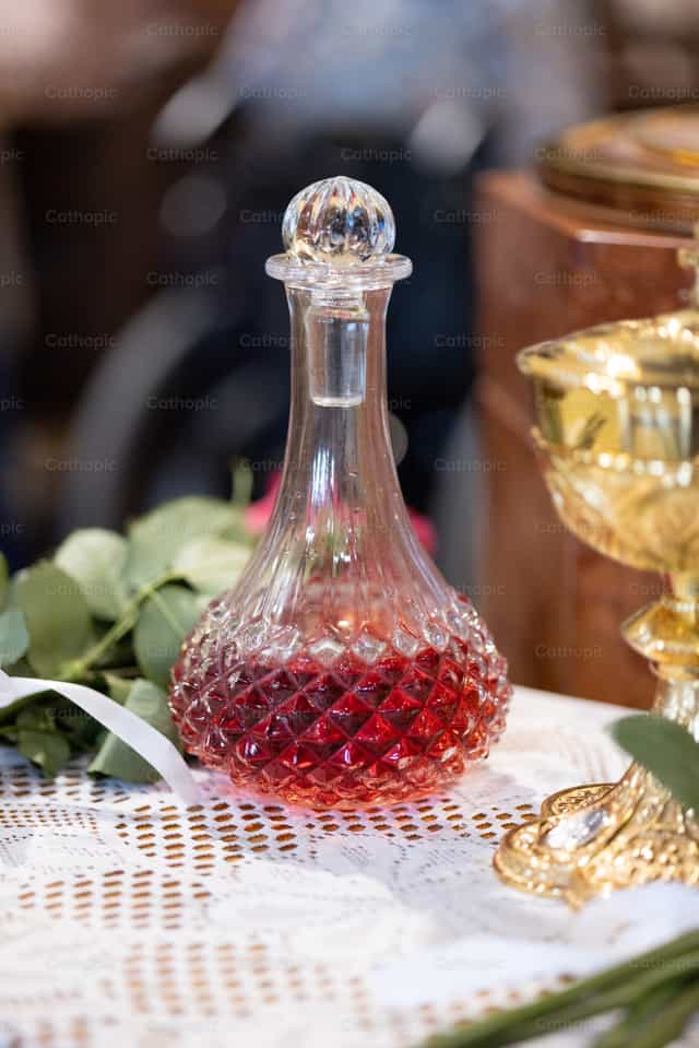 Jarra de vidrio con vino tinto en una boda católica - Banco de imágenes católicas - Fotografía por Cori Nations